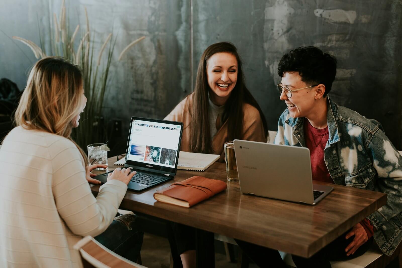 A small team working together around a table with laptops