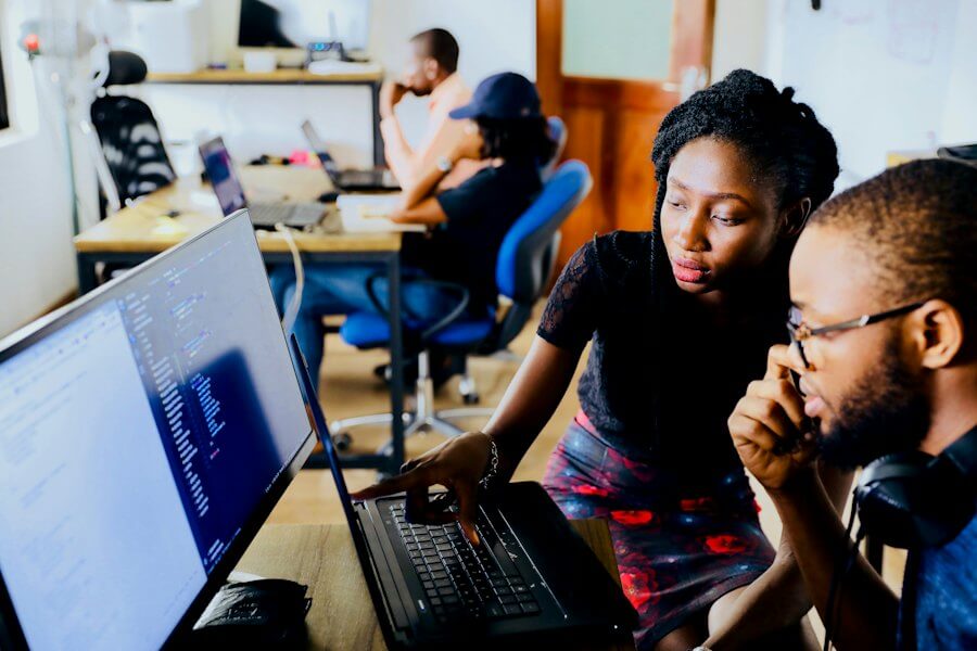 Colleagues reviewing work on a laptop