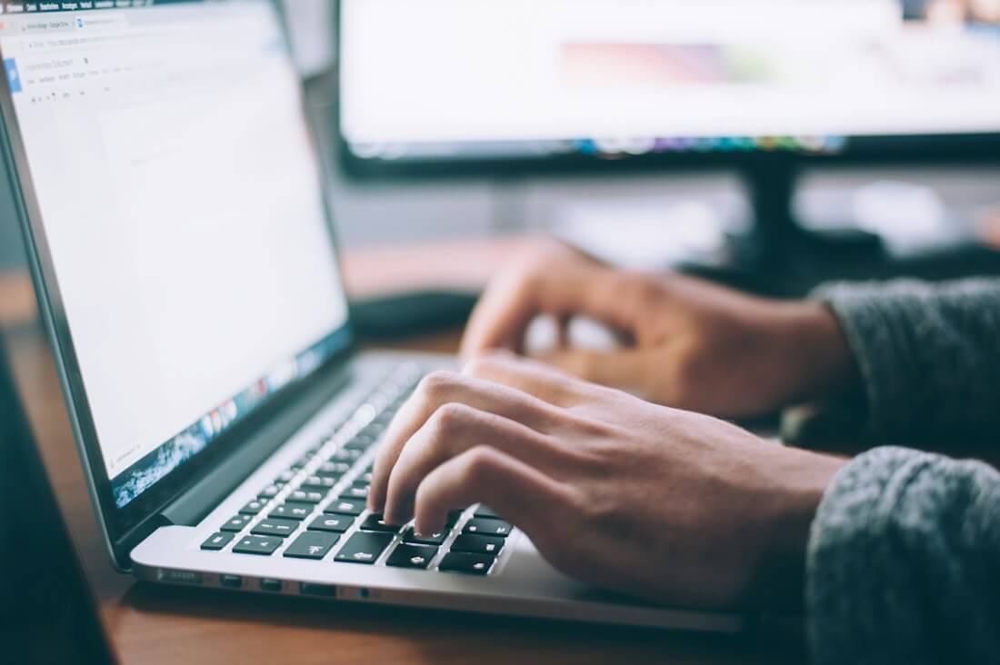 Writer typing a draft on a laptop